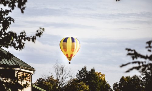A beautiful shot of a yellow hot air balloon in the cloudy sky